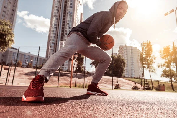 Angle bas d'un beau jeune homme jouant au basket — Photo