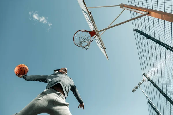 Ángulo bajo de un jugador de baloncesto saltando — Foto de Stock