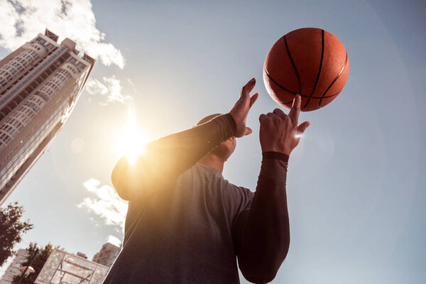 Pleasant Afro American man rotating the ball