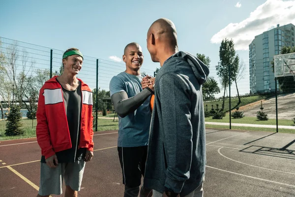 Gente positiva alegre reuniéndose en la cancha de baloncesto — Foto de Stock