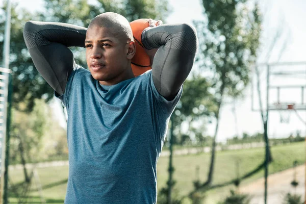 Schöner schöner Mann, der einen Ball über sich hält — Stockfoto