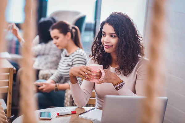 Positive delighted woman holding a cup with tea