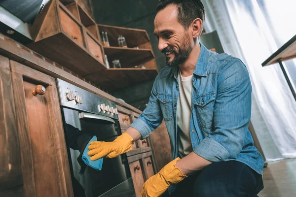 Positiv lykkelig mann som rengjør kjøkkenet – stockfoto