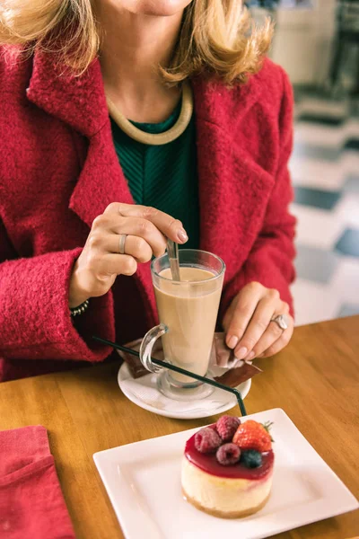 Mujer con bonito collar comiendo postre de frutas y bebiendo café con leche —  Fotos de Stock
