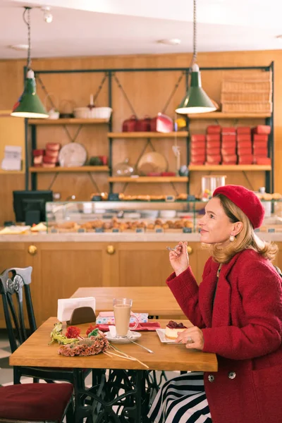 Blonde-haired French woman sitting in atmospheric cozy bakery — Stock Photo, Image