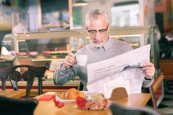Hombre francés pasando la mañana en una bonita panadería leyendo noticias de la mañana —  Fotos de Stock