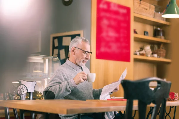 Rijpe zakenman lezen van krant en koffie drinken met baard — Stockfoto