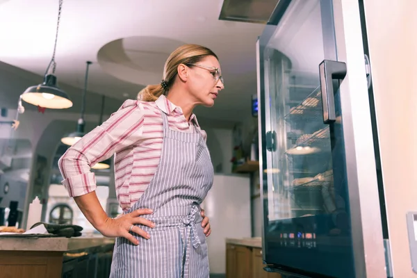 Trabalhador loiro de padaria verificando a disponibilidade de sobremesas — Fotografia de Stock