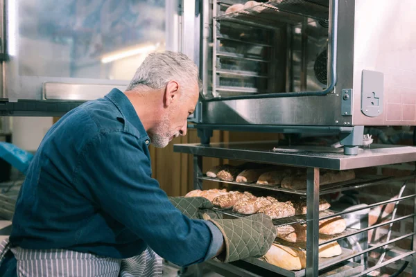 Bearded baker feeling excited before baking nice morning baguettes — Stock Photo, Image