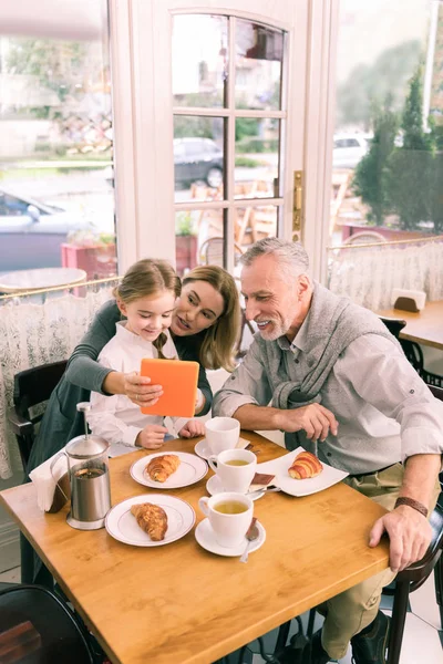 Happy beaming avós comer croissants manhã com neta — Fotografia de Stock