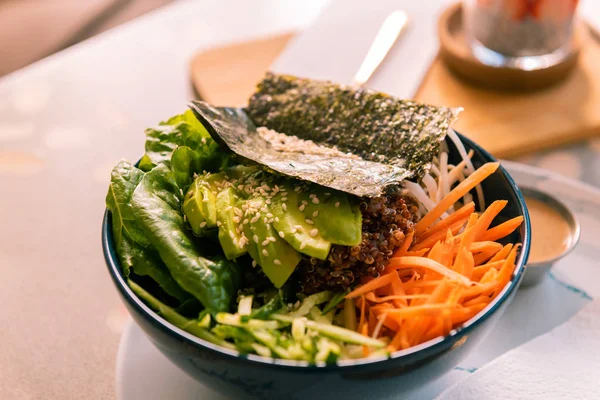 Nahaufnahme von gesundem Avocadosalat mit Karotten bestreut mit etwas Sesam — Stockfoto