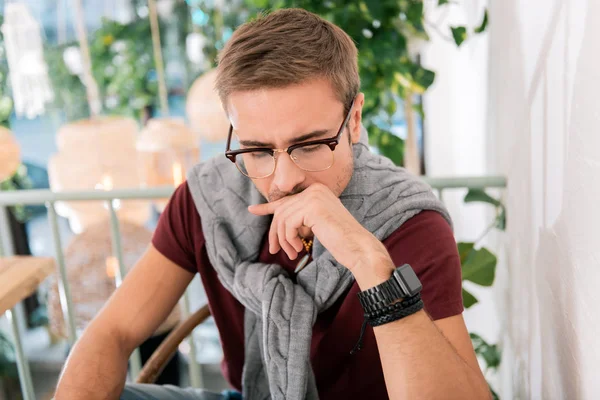 Successful businessman wearing smart watch sitting in restaurant