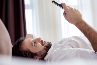 Smartphone ekrana bakarak olumlu yakışıklı adam