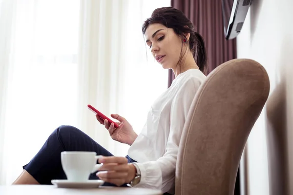 Hermosa mujer joven mirando la taza de café — Foto de Stock