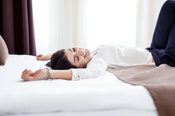 Счастливая позитивная женщина, лежащая на кровати — стоковое фото