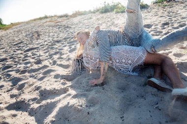 Kadın kum üzerinde yalan yakışıklı erkek sarılma beyaz dreadlocks ile