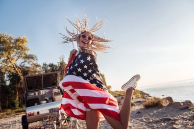 Amerikan bayrağı yüksek duygu mutlu atlama tutan neşeli kadın