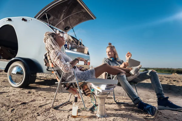 Frau mit Dreadlocks raucht Zigarette und legt ihre Beine auf Freund — Stockfoto