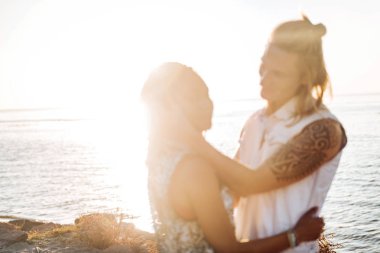 Deniz kenarında gün batımını izlemek onun kız arkadaşı sarılma dövmeli adam