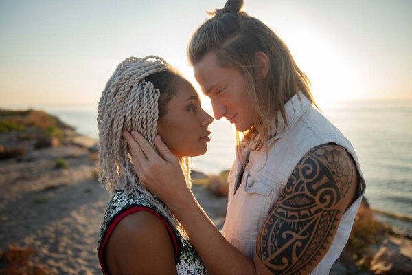 Милая любящая пара смотрит друг на друга, стоя у моря
