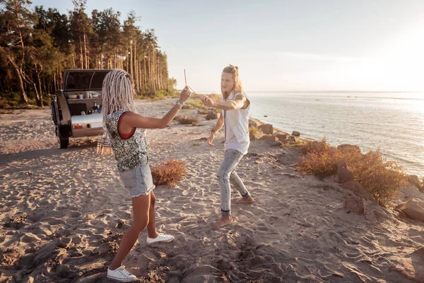 Paret i kompakt trailer nära havet att ha kul med tomtebloss i händer — Stockfoto