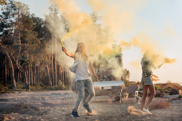 Couple wearing sneakers having fun holding fire bombs after picnic