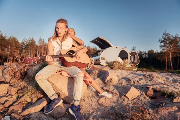 Man met lang blond haar dragen van denim kleding gitaar spelen — Stockfoto