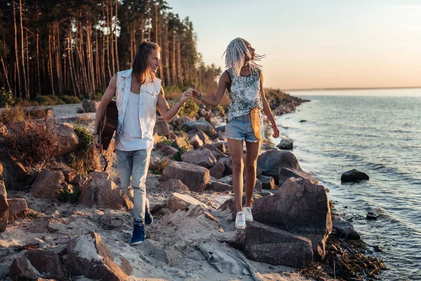 Sevecen adam kayalık sahil boyunca yürürken elini onun kız arkadaşı tutuyor — Stok fotoğraf