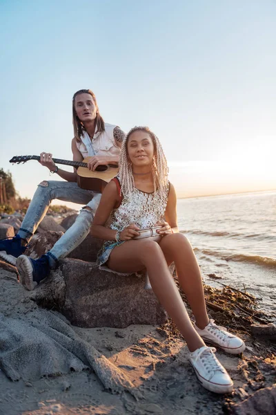 Paar creatieve muzikanten spelen hun favoriete liedje in de buurt van de kust — Stockfoto