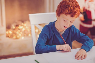 Büyüleyici Kızıl saçlı çocuk Noel arifesinde boyama