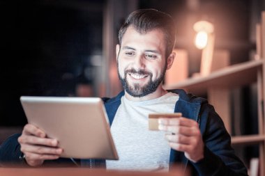 Çevrimiçi alışveriş yaparken mutlu genç erkek