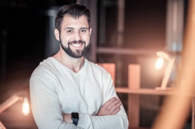 Kamerada poz veren mutlu sakallı adam.