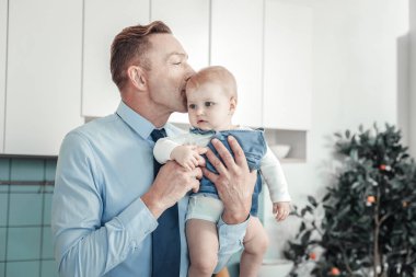 Holding ve bir bebek öpüşme hoş sevecen babası.