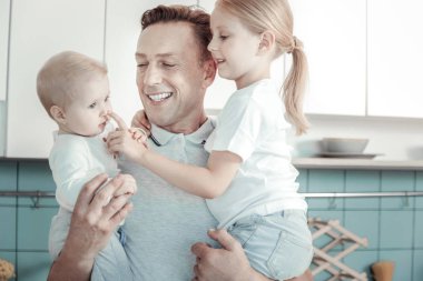 Gülümseyen ve çocuklarla oynarken neşeli bakım adam.