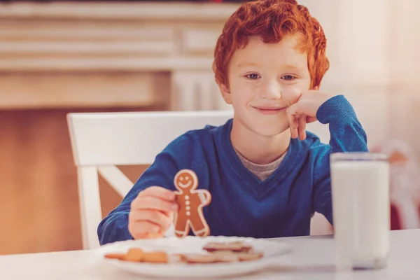 Cute boy posing while holding gingerbread man — Stock Photo, Image