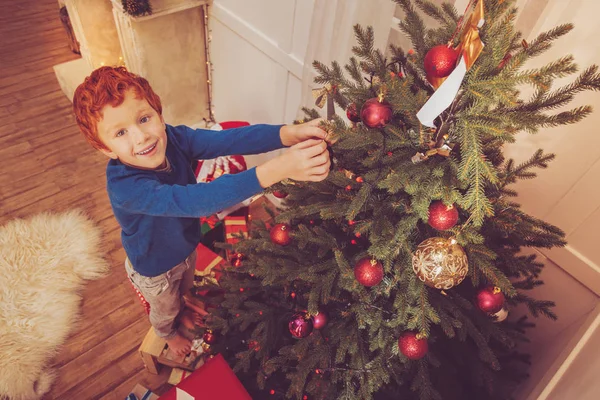 Karácsonyfa díszítő aranyos vörös hajú fiú, felülnézet — Stock Fotó