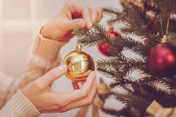 モミの木でクリスマス ボールをぶら下げ女性の手 — ストック写真