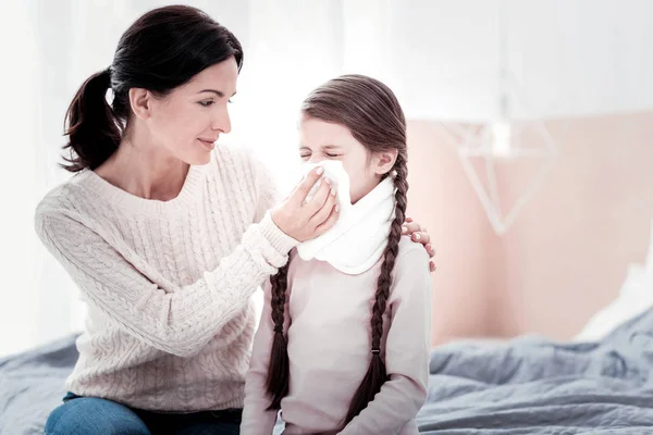 Retrato de madre joven con su hija sonándose la nariz — Foto de Stock