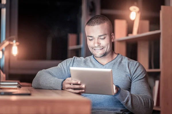 Positivo encantado homem de pele escura usando tablet — Fotografia de Stock