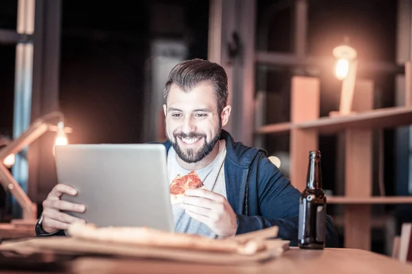 Bonito homem sorrindo enquanto come — Fotografia de Stock