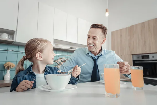 Attentive lovely father sitting and smiling. — Stock Photo, Image