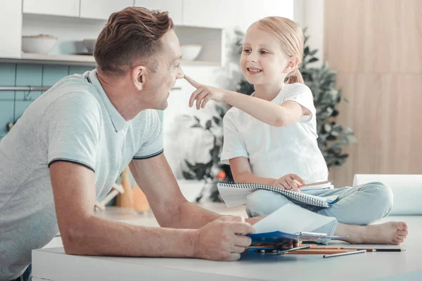 Feliz chica alegre sentado y tocando a los padres nariz . — Foto de Stock