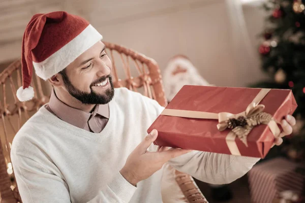 Cheerful brunette examining box with present — Stock Photo, Image