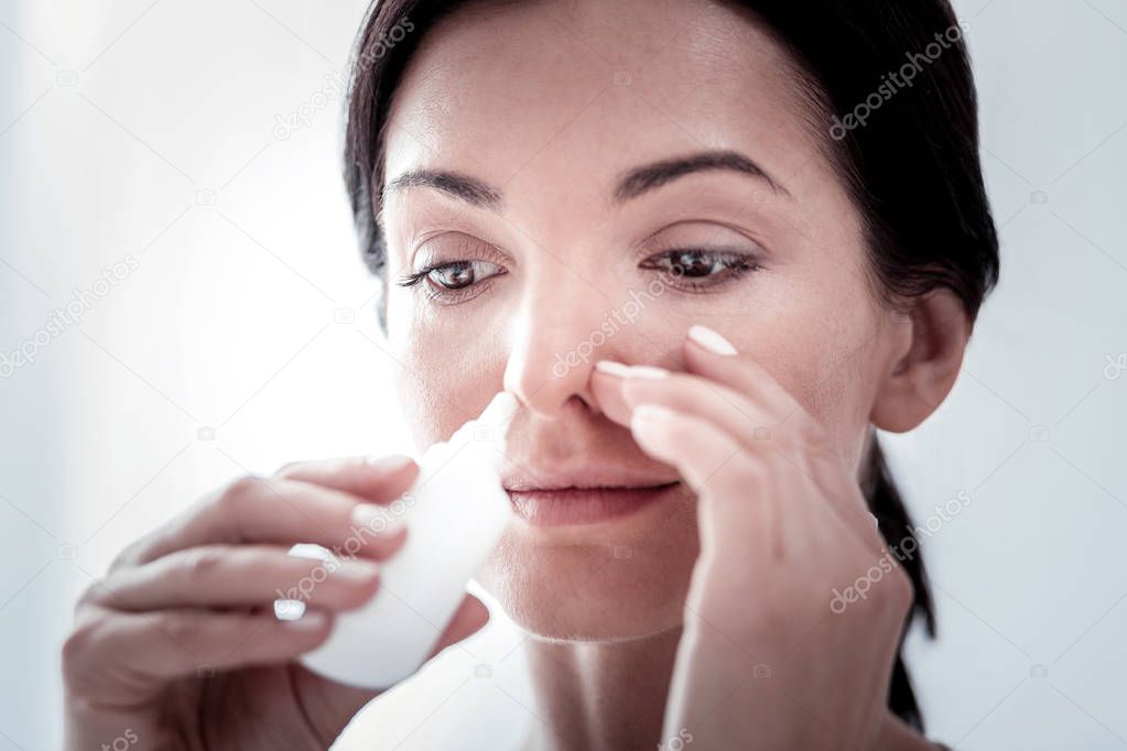 Close up of a woman dripping her nose
