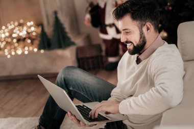 Neşeli erkek kişi yarı pozisyonda oturuyor