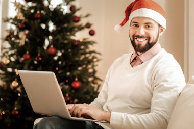 Noel Baba şapkası giyen mutlu sakallı adam