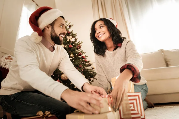 Alegre animado casal olhando para o Natal presentes — Fotografia de Stock