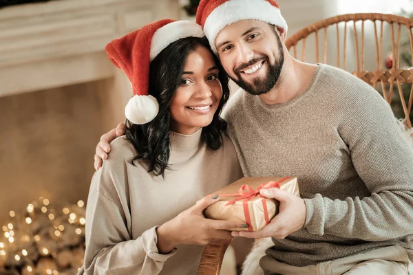 Positive happy couple holding a gift box — Stock Photo, Image