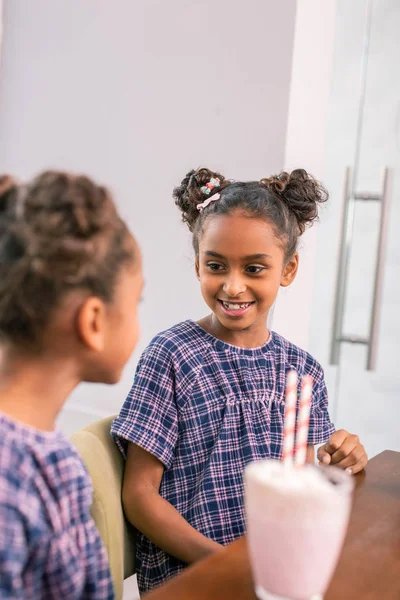 Malá školačka fialové hranaté šatech při pohledu na mladší sestra — Stock fotografie