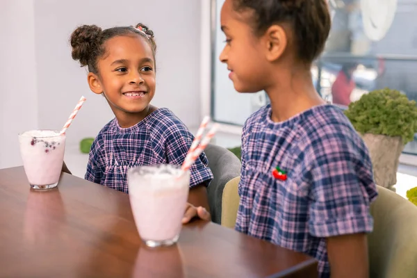 Dvě děti nosí stejné fialové kvadratických šaty pít ovocné smoothies — Stock fotografie